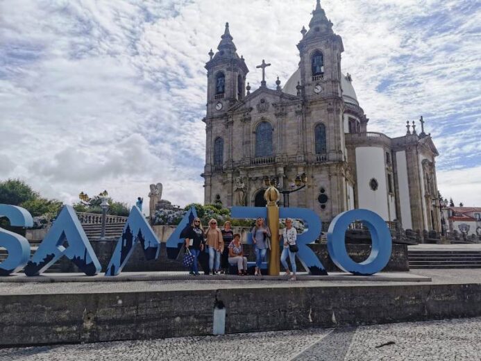 Zwiedzanie Portugalii w wolnym czasie. Nauczyciele pozujący do zdjęcia na tle zabytkowego kościoła.