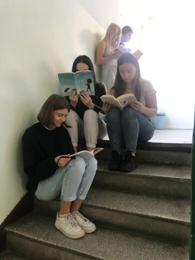 Uczennice czytają książki podczas akcji "Przerwa na czytanie".