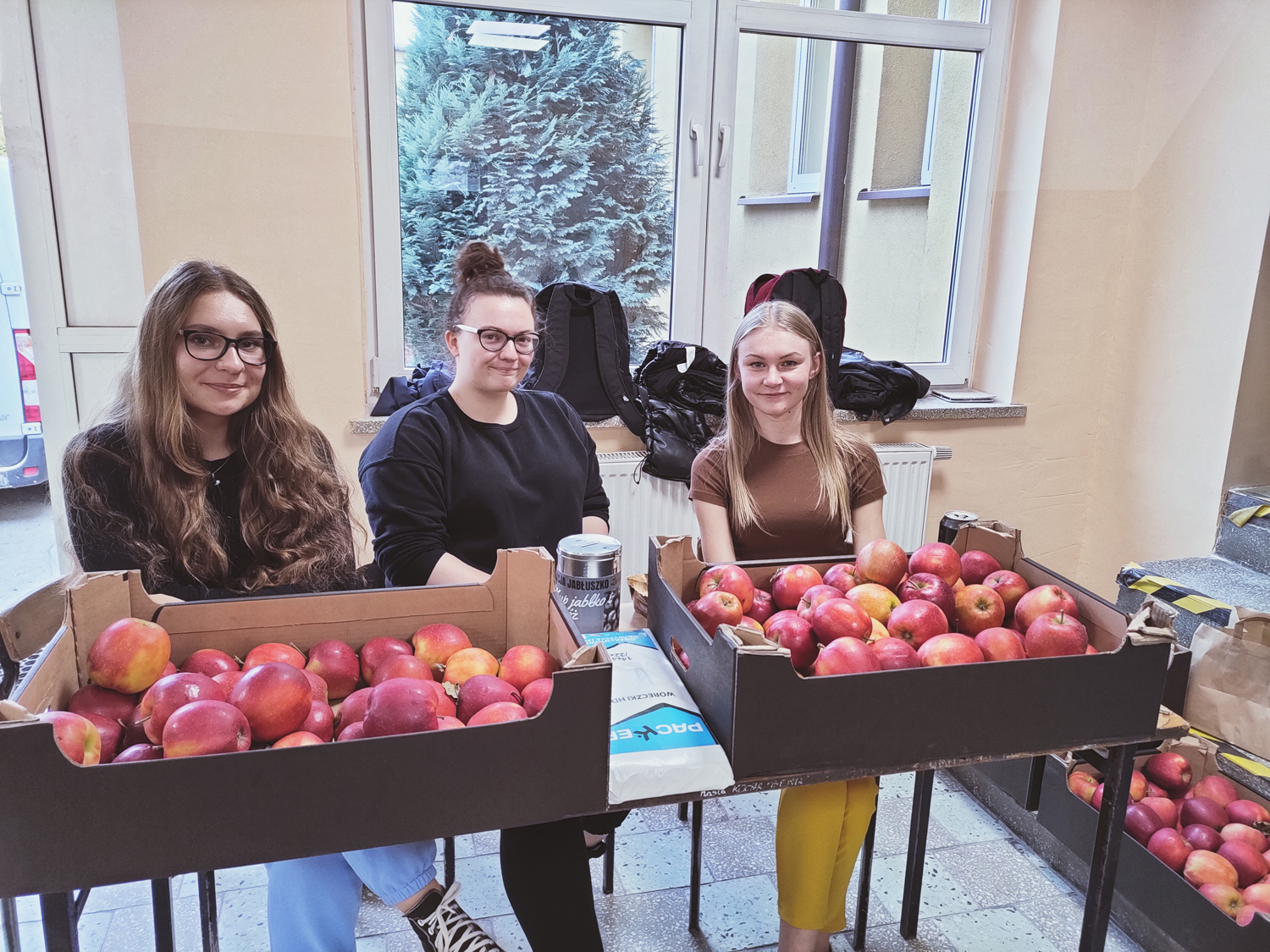 Uczennice biorące udział w akcji charytatywnej podczas sprzedaży jabłek