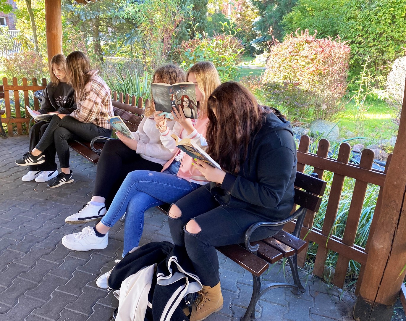 Akcja przerwa na czytanie - uczennice czytają książki w parku przy hali Arkadia