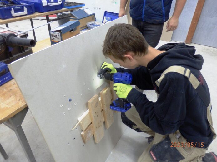 Uczeń wykonuje ćwiczenia dotyczące instalacji budowlanych z wykorzystaniem kołków i wkrętów.