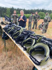 Rajd rowerowy trasą "Doliny Baryczy" oraz turniej paintballowy. Drużyny ubierają stroje ochronne do turnieju paintballowego. Na pierwszym planie widać stół z przygotowanymi goglami ochronnymi.