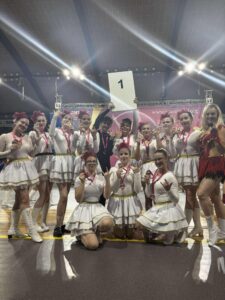 Zdjęcie grupowe zespołu UKS Mażoretki Artis Góra biorącego udział w XXVI Mistrzostwa Polski Mażoretek w Kędzierzynie-Koźlu wraz ze zdobytymi medalami, w tym m. in. Mistrzostwa Polski w kat. scena buława seniorki „Upiór w operze".