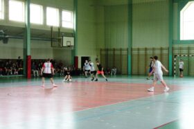 Jedną z atrakcji "Dnia sportu" był turniej piłki nożnej halowej. Zdjęcie jednego z meczów turniejowych. Zawodnik stracił równowagę podczas biegu i próbuje utrzymać się przy piłce.