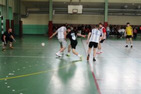 Jedną z atrakcji "Dnia sportu" był turniej piłki nożnej halowej. Zdjęcie jednego z meczów turniejowych. Strzał na bramkę między nogami obrońcy.