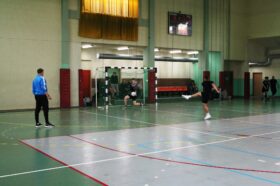 Jedną z atrakcji "Dnia sportu" był turniej piłki nożnej halowej. Zdjęcie jednego z meczów turniejowych. Zawodnik wykonuje rzut karny. Strzał w środek bramki, bramkarz broni to uderzenie.