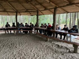 Uczniowie podczas wyjścia na strzelnicę z okazji Dnia Chłopaka jedli kiełbaski z grilla.