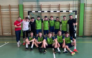 Zdjęcie grupowe drużyny reprezentującej naszą szkołę z trenerami na powiatowym turnieju piłki halowej chłopców.